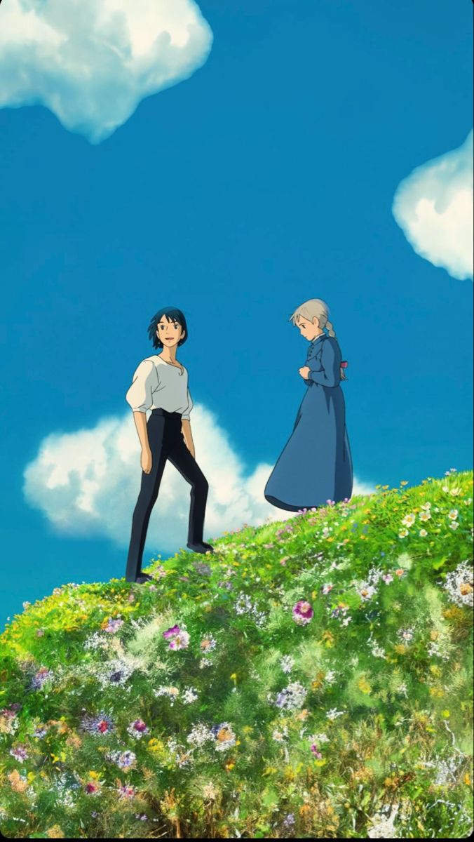 two people standing on top of a lush green hillside under a blue cloud filled sky