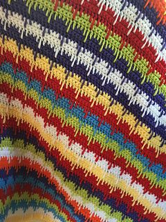 a colorful crocheted blanket is on display