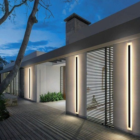 an exterior view of a modern house at night with lights on the windows and shutters