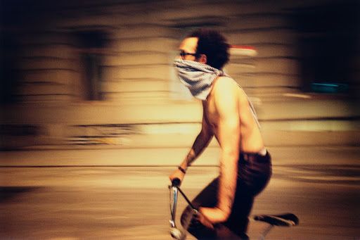 a man riding a bike wearing a bandana