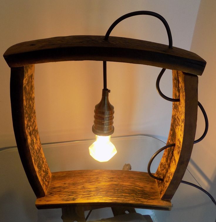 a wooden light fixture sitting on top of a glass table