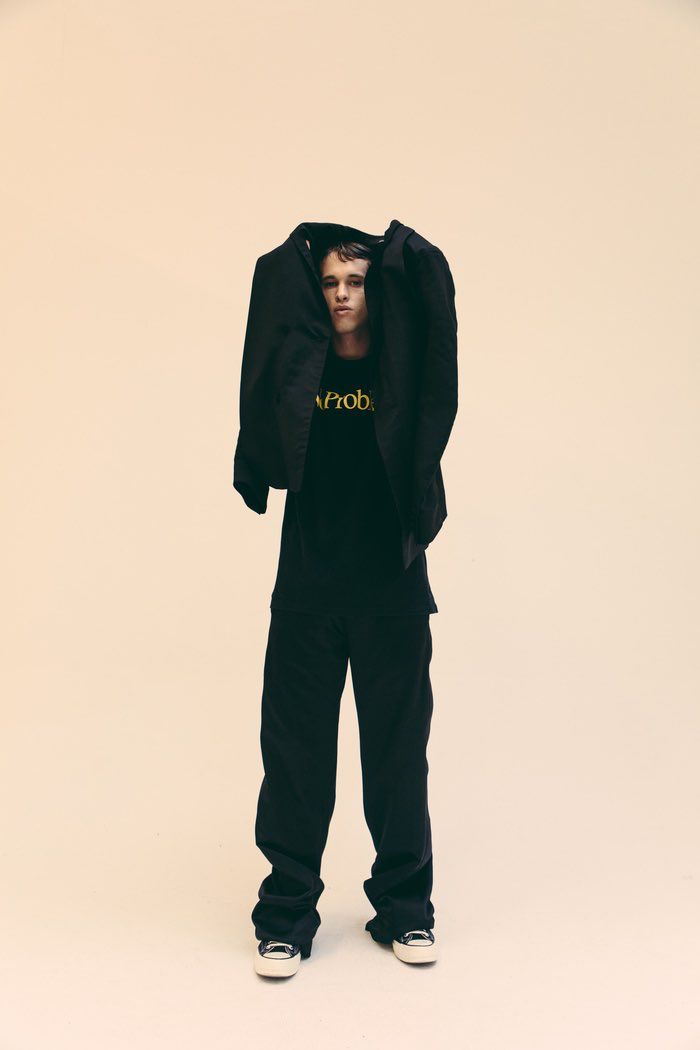 a man wearing a hoodie and black sweatpants standing in front of a white background