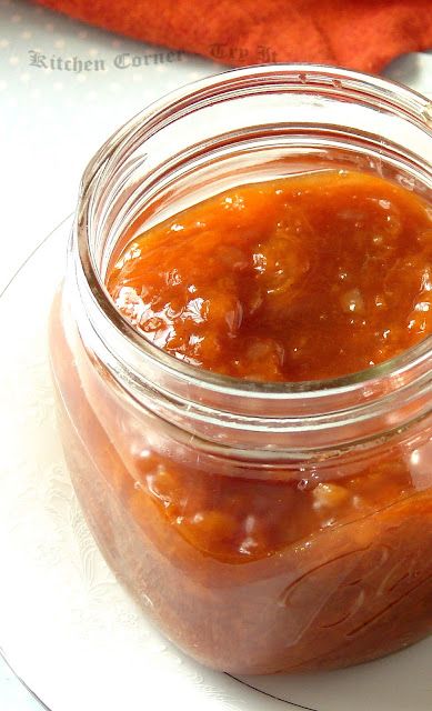 a glass jar filled with sauce sitting on top of a white plate next to a red towel