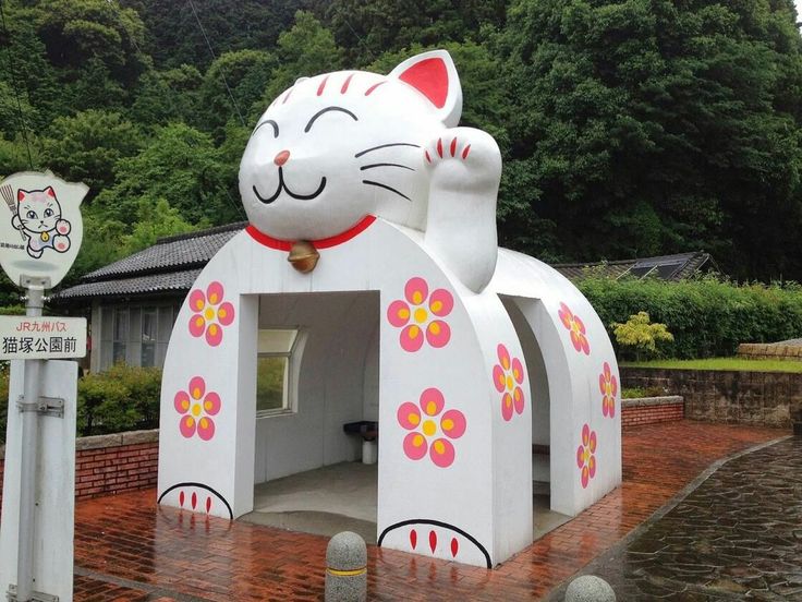 a cat shaped building with flowers painted on it