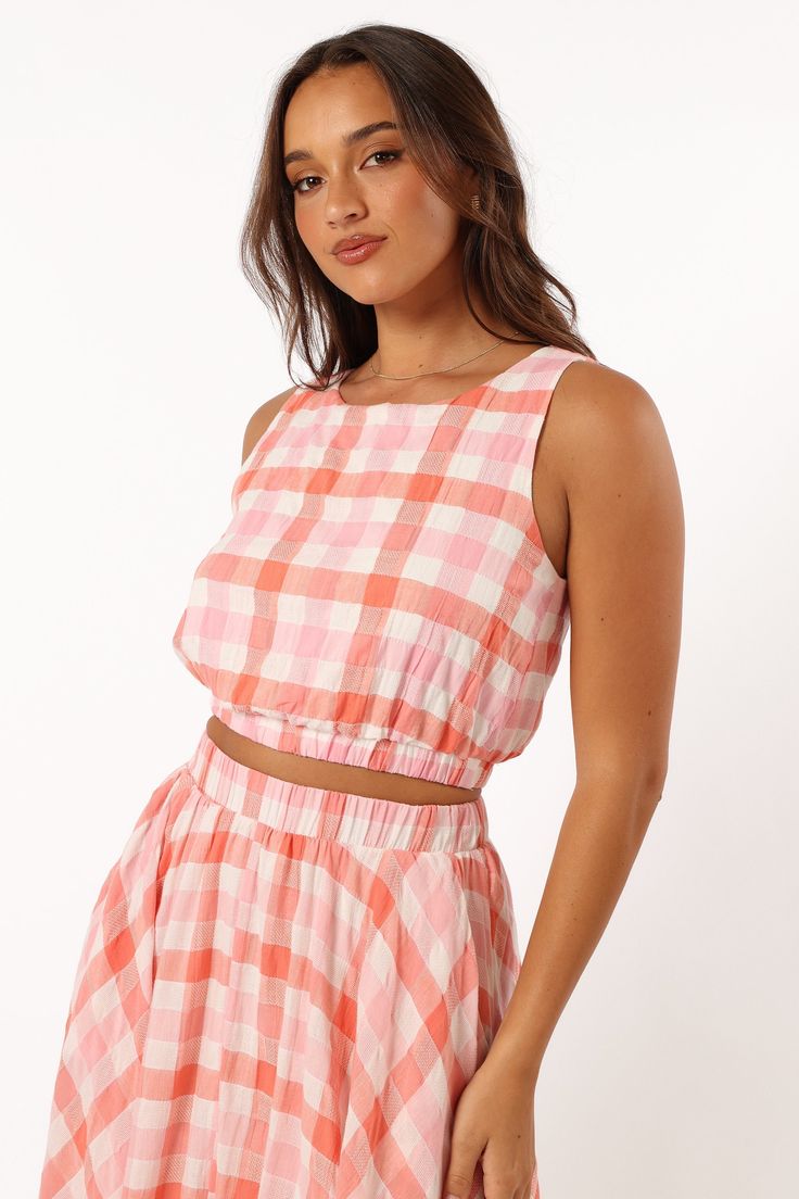 DETAILS   Our Betty Top is the perfect go-to for any sunny day. It features a cropped length, non adjustable straps and an elasticised waistband to keep you stylish and comfortable all day long. With a pink gingham print design to make you stand out from the crowd.   cropped length  round neckline  non adjustable straps  elasticised waistband  gingham print  lined  m aterial - 100% cotton / lining - 100% rayon     SIZING      studio model is 5' 7" and wears a Size S    model stats: bust - 33", w Pink Crop Top With Adjustable Straps, Pink Cropped Top For Vacation, Spring Beach Crop Top With Elastic Waistband, Casual Crop Top With Elastic Waistband For Beach, Summer Beach Crop Top With Elastic Waistband, Summer Crop Top With Elastic Waistband For Beach, Spring Crop Top With Elastic Waistband, Spring Crop Top With Elastic Waistband Suitable For Summer, Summer Crop Top With Elastic Waistband For Vacation