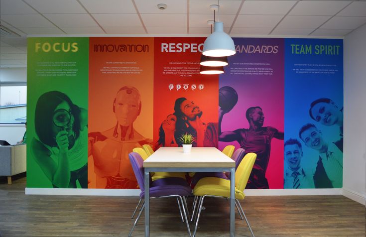 an office with colorful wallpaper and chairs in front of a table that has a plant on it