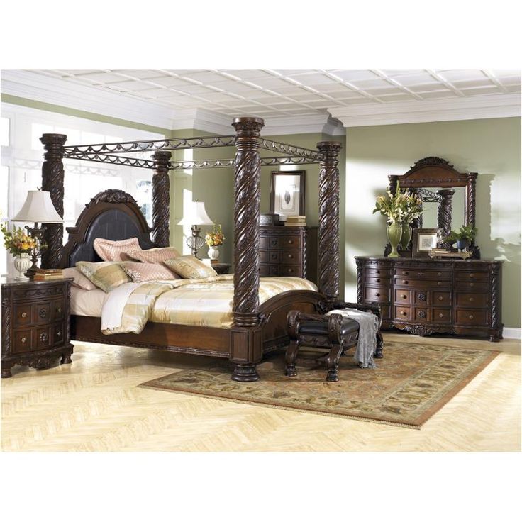 a bedroom with a canopy bed, dresser and night stand in it's center