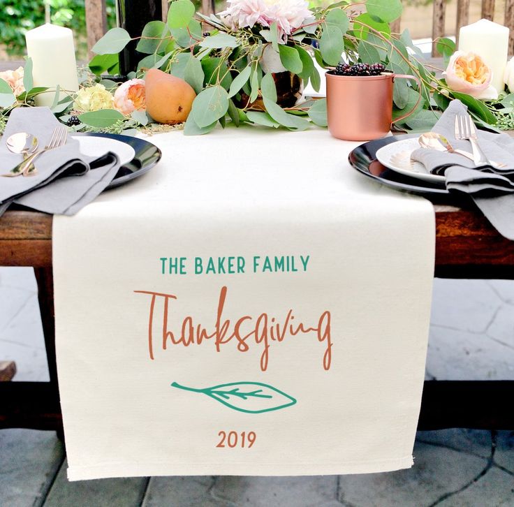 the table is set with plates and silverware on it, along with napkins that say gather together