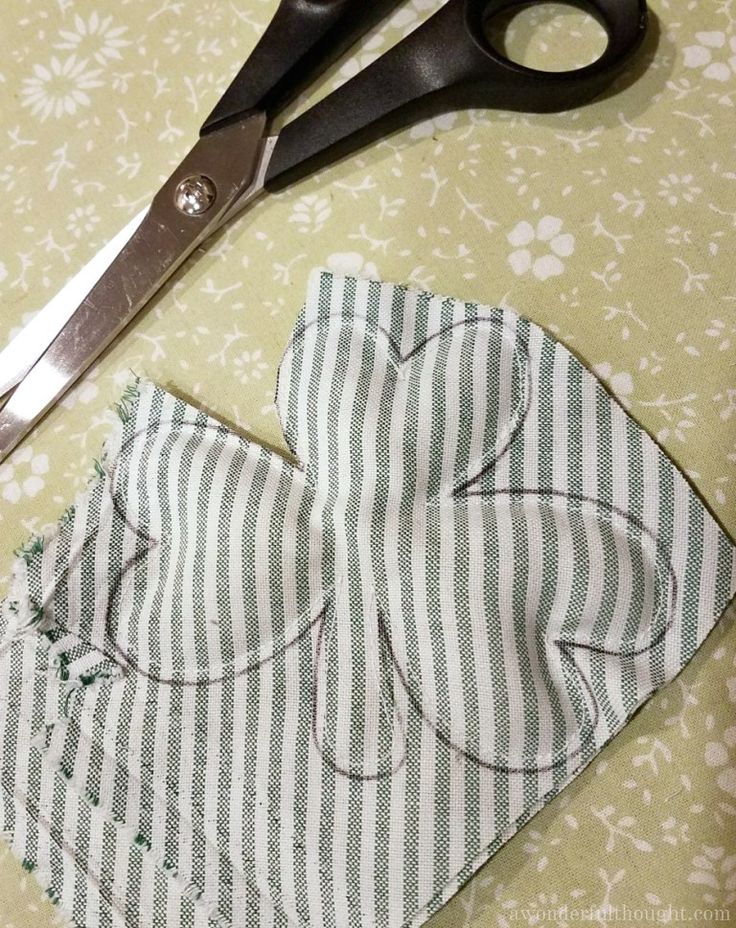 a pair of scissors sitting on top of a piece of cloth next to a sewing machine