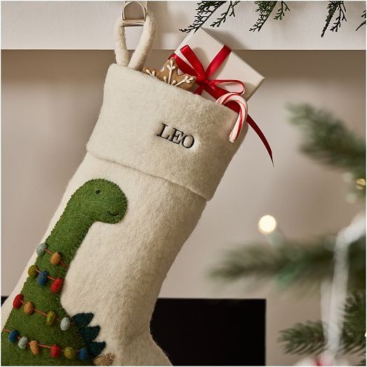 a christmas stocking with a green dinosaur on it