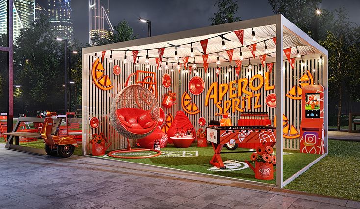 an outdoor booth with decorations and lights on the grass in front of a cityscape