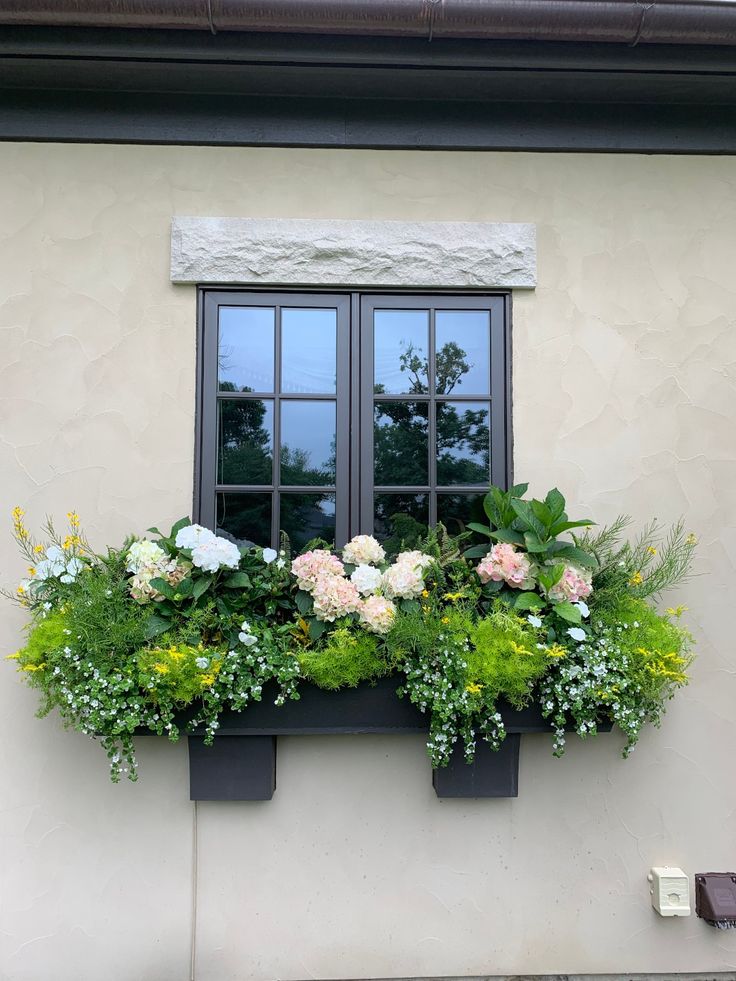 a window box filled with flowers and greenery