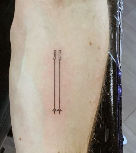 a person with a small tattoo on their left arm that has two arrows in it