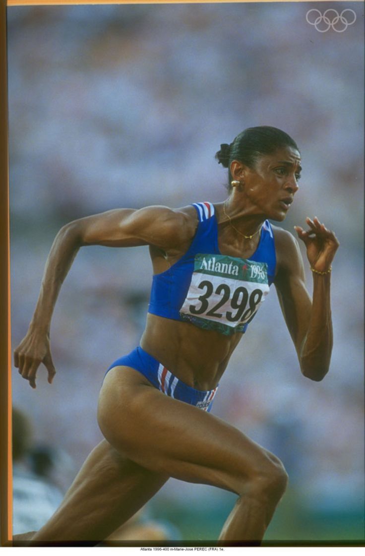 a woman running on a track in front of a crowd