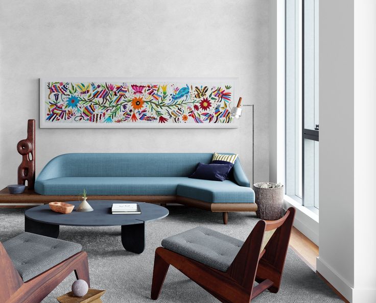 a living room filled with furniture and a painting on the wall