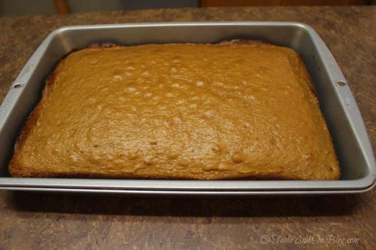 a square cake in a metal pan on a wooden table