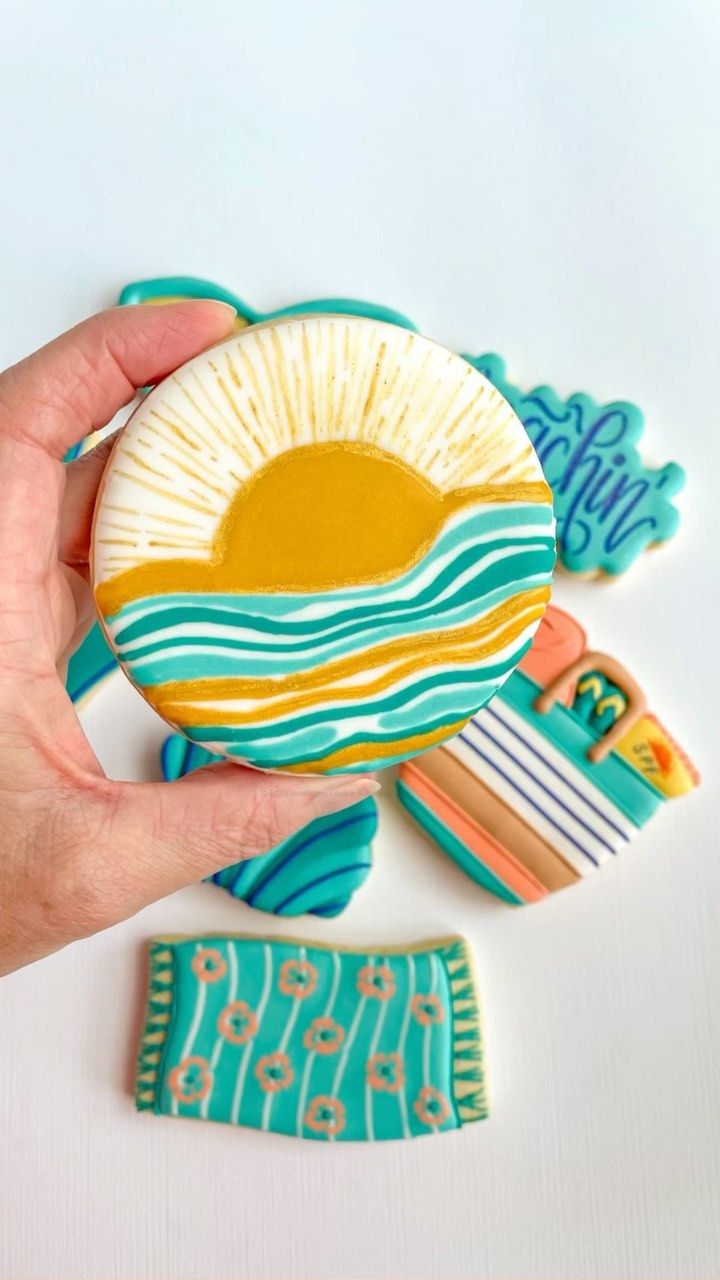 a hand holding a small ceramic plate with an image of the sun and ocean on it