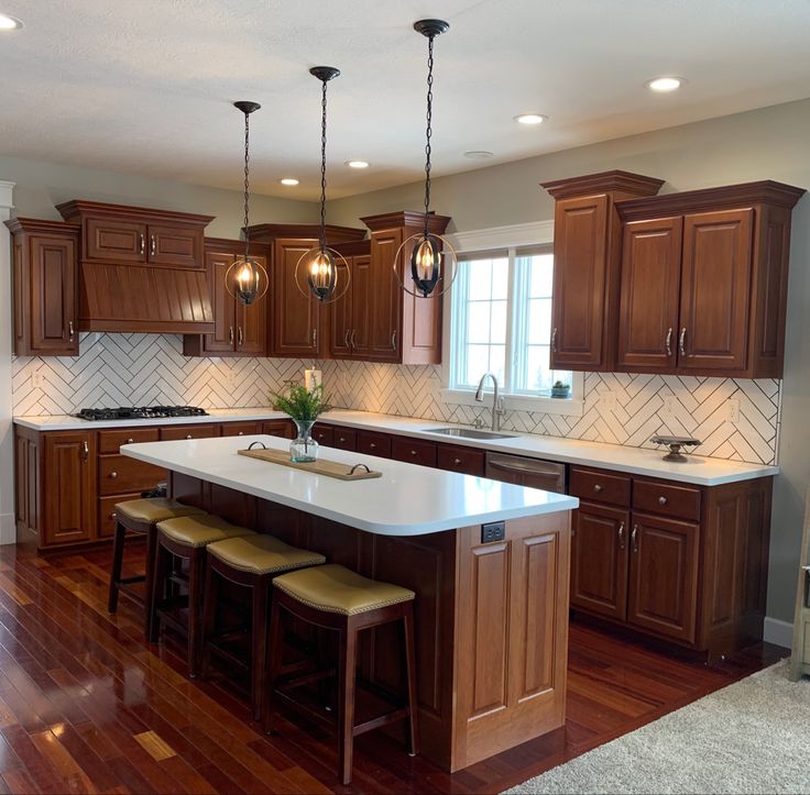 a large kitchen with wooden cabinets and white counter tops on a hard wood flooring