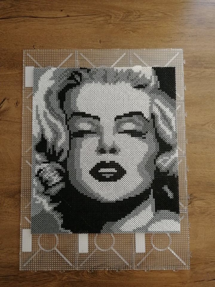 a piece of art that looks like marilyn monroe on a table with wood flooring