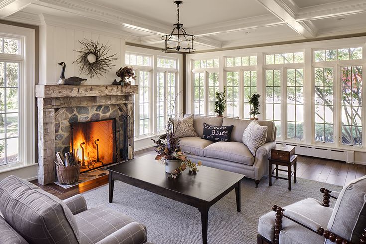 a living room filled with furniture and a fire place in the middle of a room