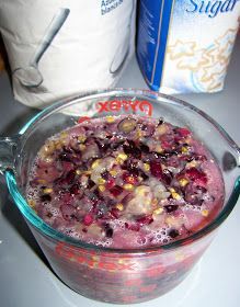 a glass bowl filled with food on top of a counter next to a bag of sugar