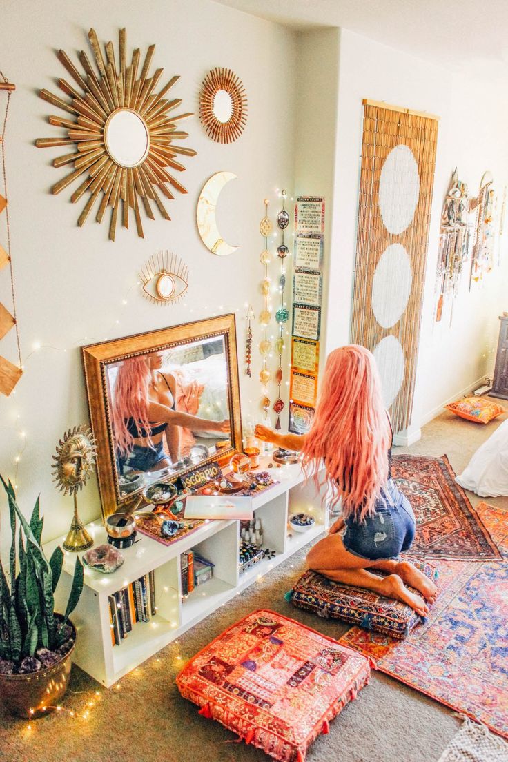 a woman sitting on the floor in front of a mirror