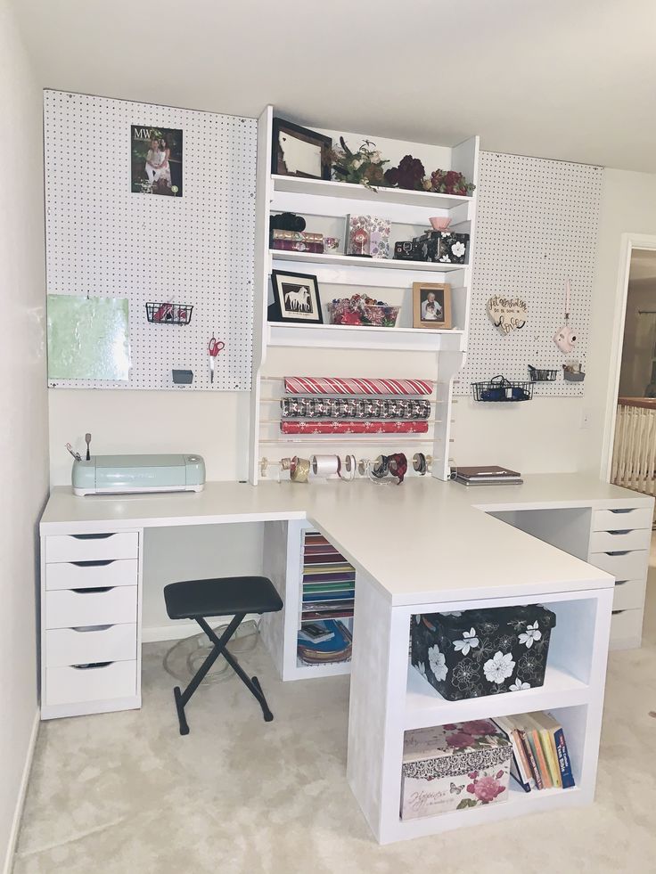 a white desk topped with lots of drawers next to a shelf filled with books and other items