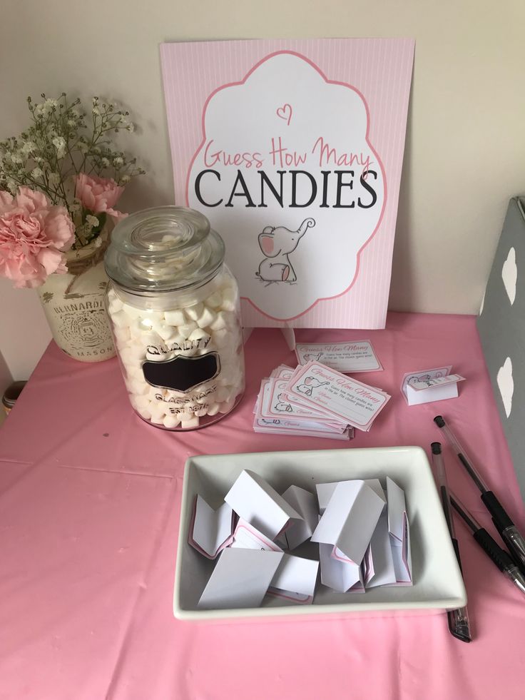 a table topped with lots of candy next to a sign and some jars filled with candies