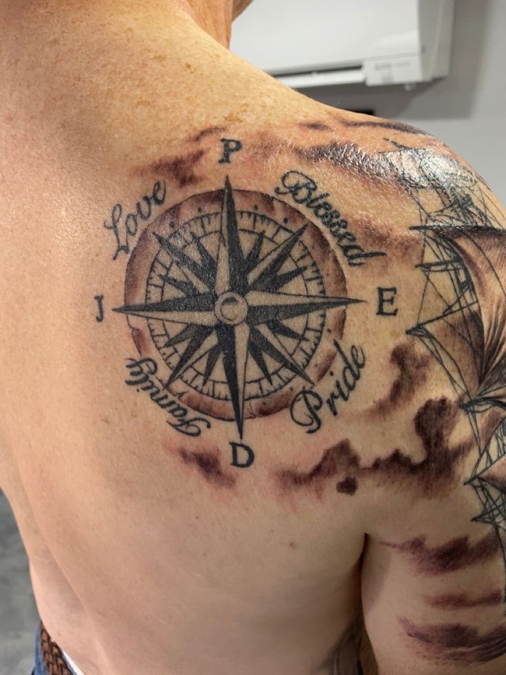 a man with a compass tattoo on his shoulder