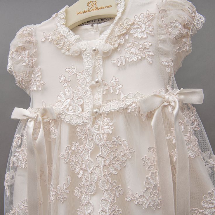 a white dress with lace and bows on it