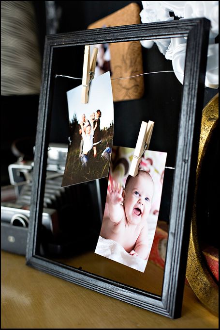 a black frame with pictures hanging from it's sides on a table next to other items