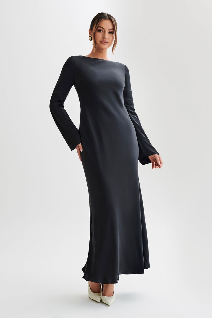 For the best dressed guest. Step into refined elegance with the RAYLEIGH Long Sleeve Satin Maxi Dress, a luxurious ensemble tailored for sophistication and grace. Featuring long sleeves that exude timeless charm, this dress boasts a keyhole and button closure at the back neckline, adding a touch of allure to its design. With a slip-on design and no closure, it ensures effortless wear, while the lining offers comfort and coverage. Complete with a maxi length, the Rayleigh dress is perfect for mak Black Maci Dress, Black Long Sleeve Dress Classy, Black Long Sleeve Maxi Dress Outfit, Long Sleeve Slip Dress, Long Sleeve Wedding Guest Dress Winter, Slip Dress With Sleeves, Satin Modest Dress, Long Sleeve Maxi Dress Formal, Modest Wedding Guest Dress