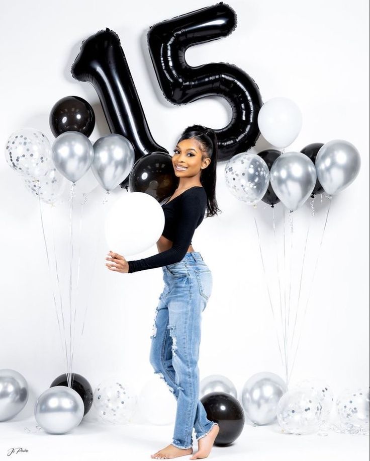 a woman standing in front of balloons with the number fifteen on it's side