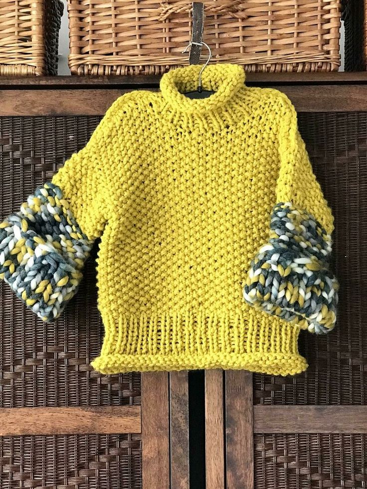 a yellow sweater hanging on a clothes rack