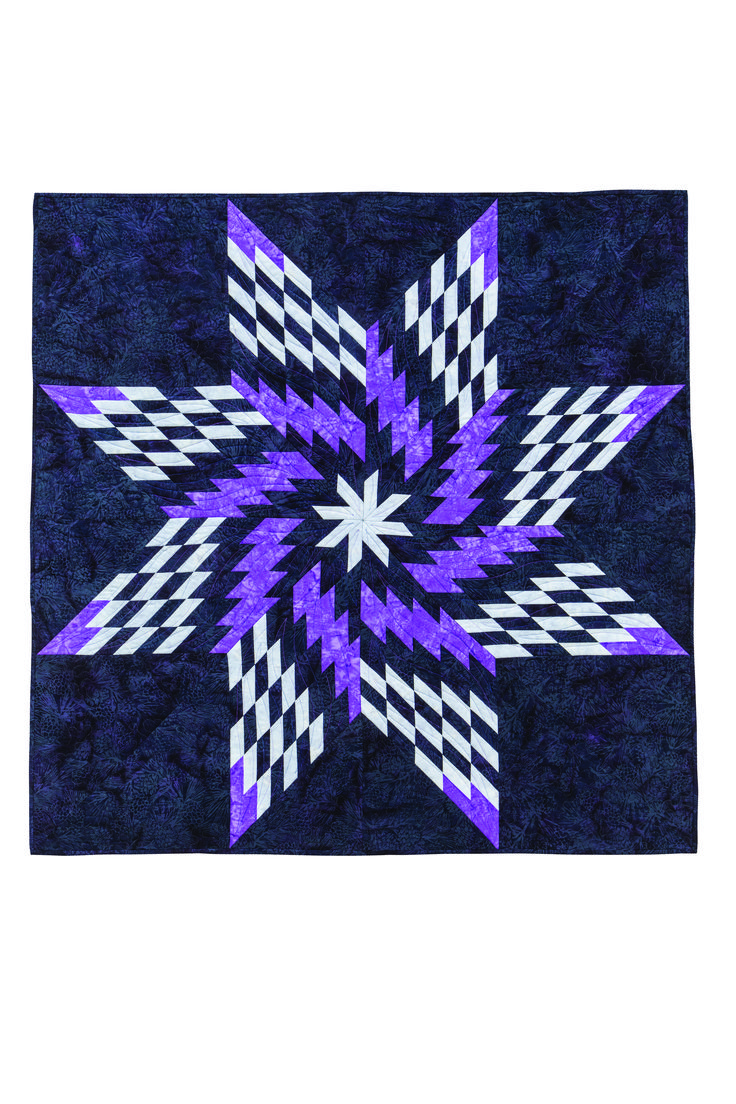 a purple and white quilt with an intricate star design on the center, in front of a white background