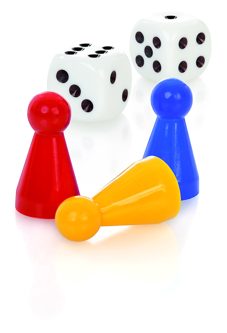 three different colored plastic dices and one with black dots on them sitting next to each other