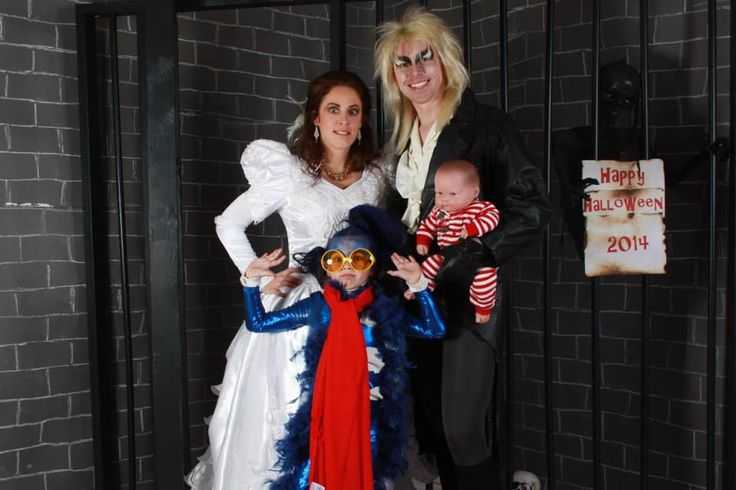 two women and a baby dressed up in halloween costumes standing next to a jail cell