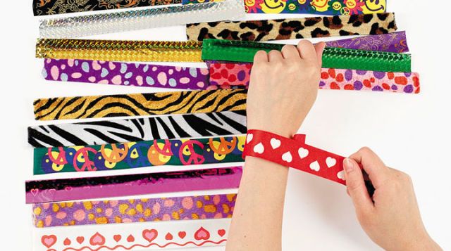 a person holding a pencil in front of many different types of ribbons on a white surface