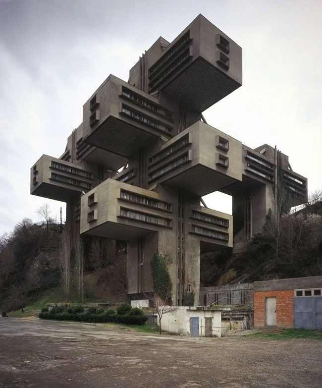 the building is made out of concrete and has multiple stories on each level, with balconies at the top