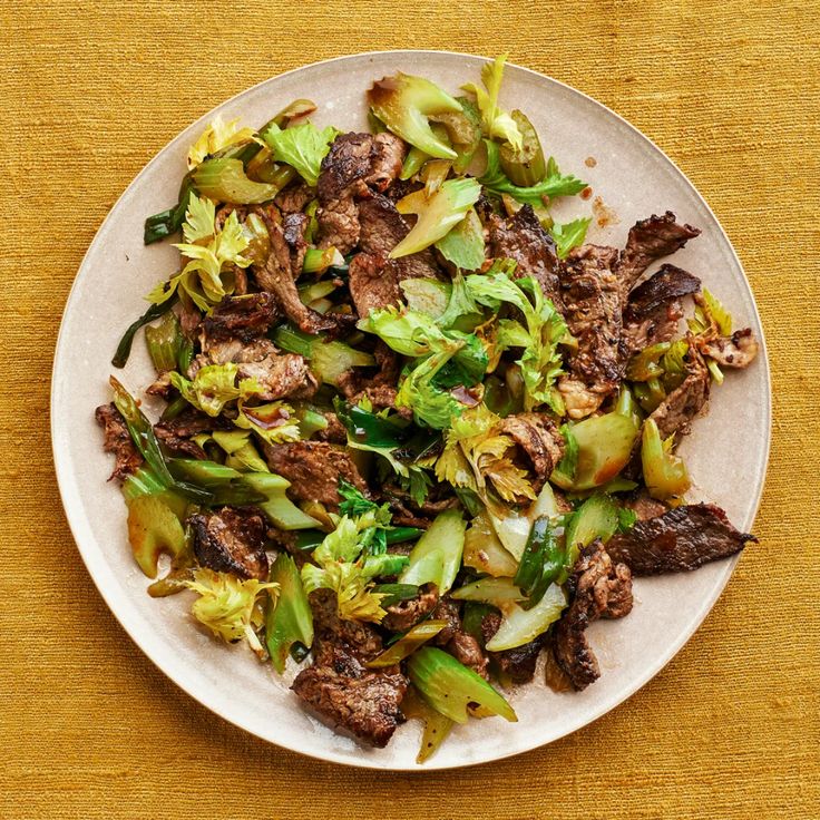 a white plate topped with beef and broccoli