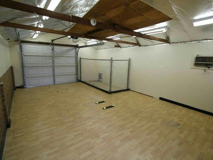 an empty room with hard wood floors and garage doors