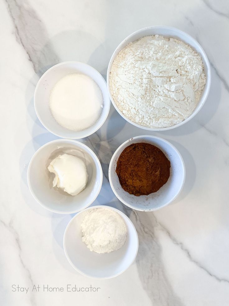 four bowls filled with different types of food on top of a marble countertop next to each other