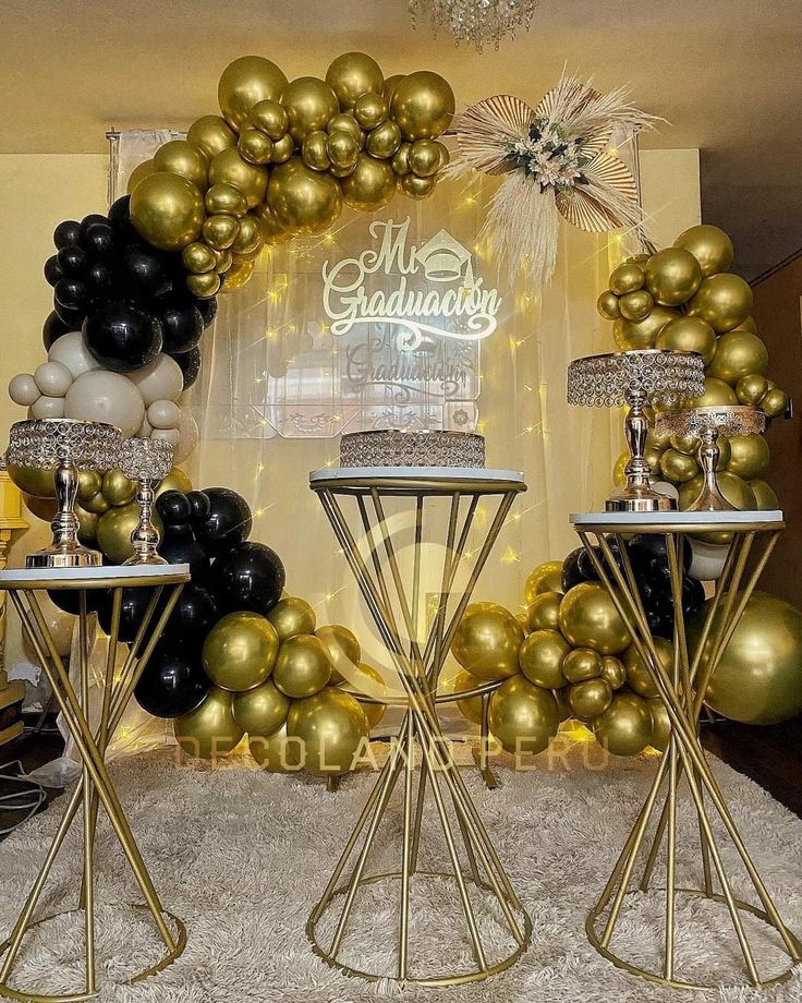 a table topped with gold and black balloons