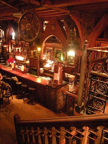 an old fashioned bar is lit up at night