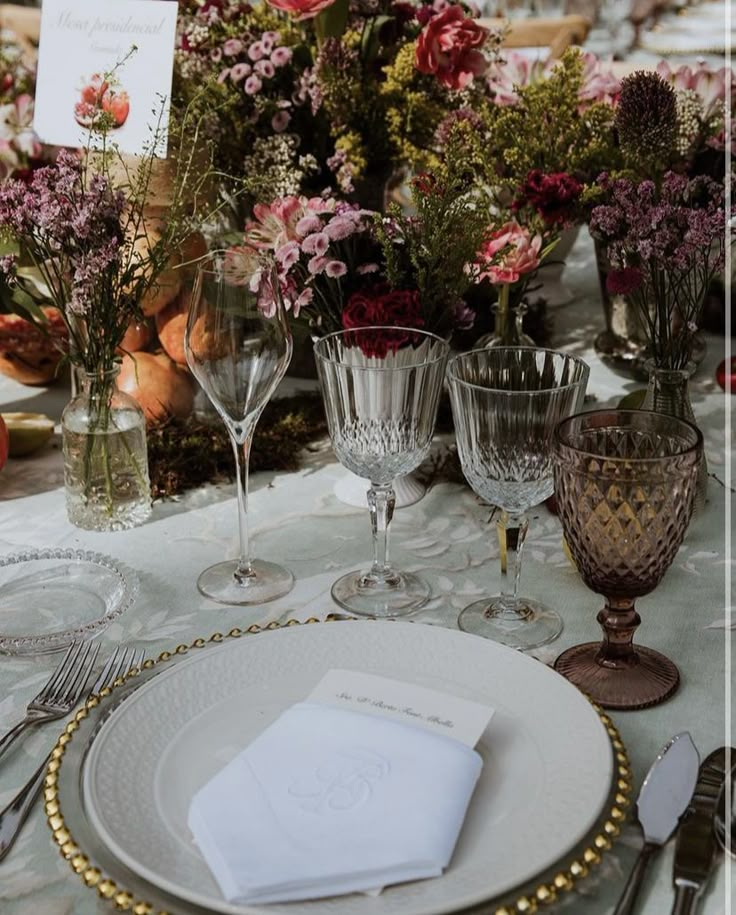 the table is set with place settings and flowers