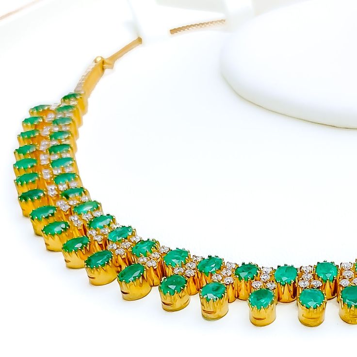 This exquisite 18k yellow gold necklace set, weighing 41.8 grams, features a luxurious design adorned with dazzling diamonds and vibrant emeralds. The yellow gold finish enhances its elegant appeal, making it perfect for any special occasion. The set includes a necklace with a total diamond weight of 2.95 carats, featuring F-G color and VS quality diamonds. The necklace has a length of 15 inches with adjustable 1.1-inch links and is secured with a hook lock. The matching earrings, each measuring Gold Plated Emerald Necklace For Formal Events, Formal Gold Plated Emerald Necklace, Formal Gold-plated Emerald Necklace, Luxury Hand Set Round Emerald Necklace, Luxury Hand-set Round Emerald Necklace, Elegant Yellow Gold Plated Emerald Necklace, Elegant Yellow Gold-plated Emerald Necklace, Luxury Hand-set Emerald Necklace, Fine Jewelry Emerald Necklace In Gold