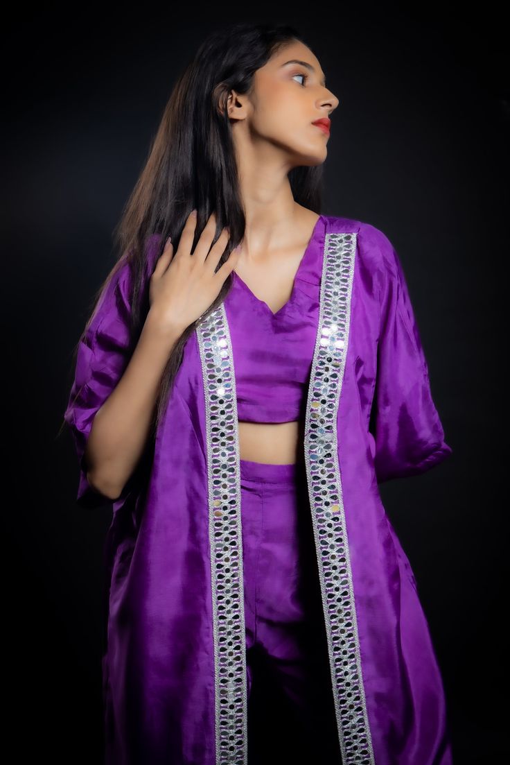 Achieving a perfect balance between traditional craft, contemporary silhouette, and sustainability, this breezy purple co-ord set made from vegan uppada silk is a stunning example of craftsmanship. Embellished with glistening mirror work and a zari border, this look is an impeccable fusion of style, elegance, and sustainability.Details Neckline: V Neck Material: Uppada silk Lining: Cotton-polyester Made in India What makes this outfit sustainable?Uppada silk, made from a viscose blend, is a sust Bollywood Style Purple Palazzo Set For Party, Elegant Lavender Sets For Festive Occasions, Elegant Lavender Festive Sets, Elegant Festive Lavender Sets, Purple Sets With Mirror Work For Party, Festive Purple Palazzo Set For Party, Purple Party Sets With Mirror Work, Purple Party Set With Mirror Work, Elegant Purple Sets With Mirror Work