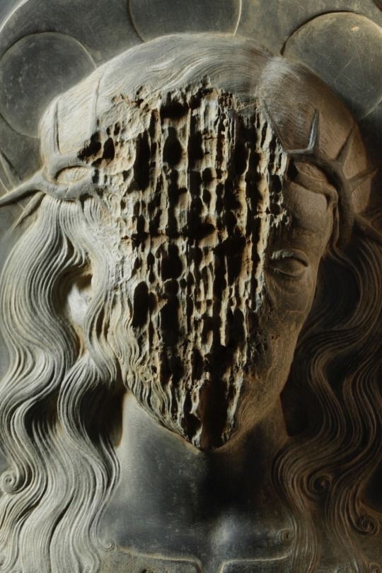 a close up of a statue with an intricate design on it's face and head