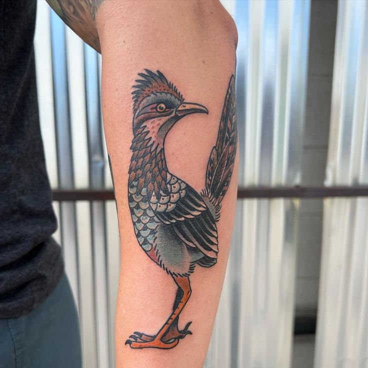 a man's arm with a bird tattoo on it