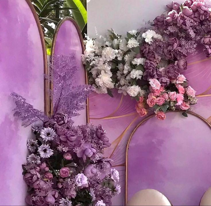 purple and white flowers are placed on the back of surfboards in front of a wall